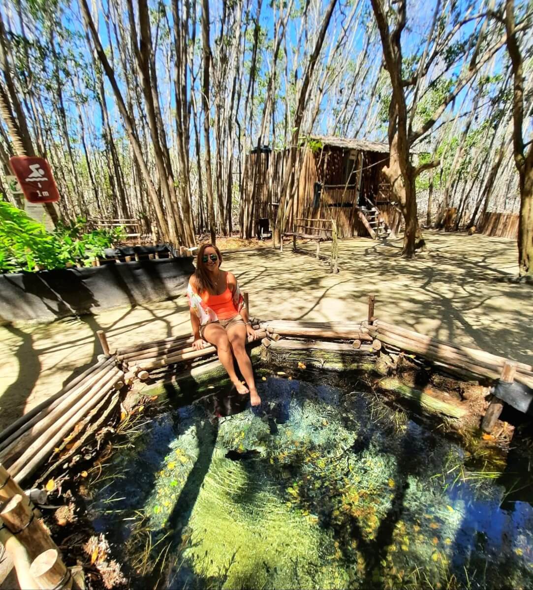 Viajera tomándose un momento con los pies en el agua de un cenote